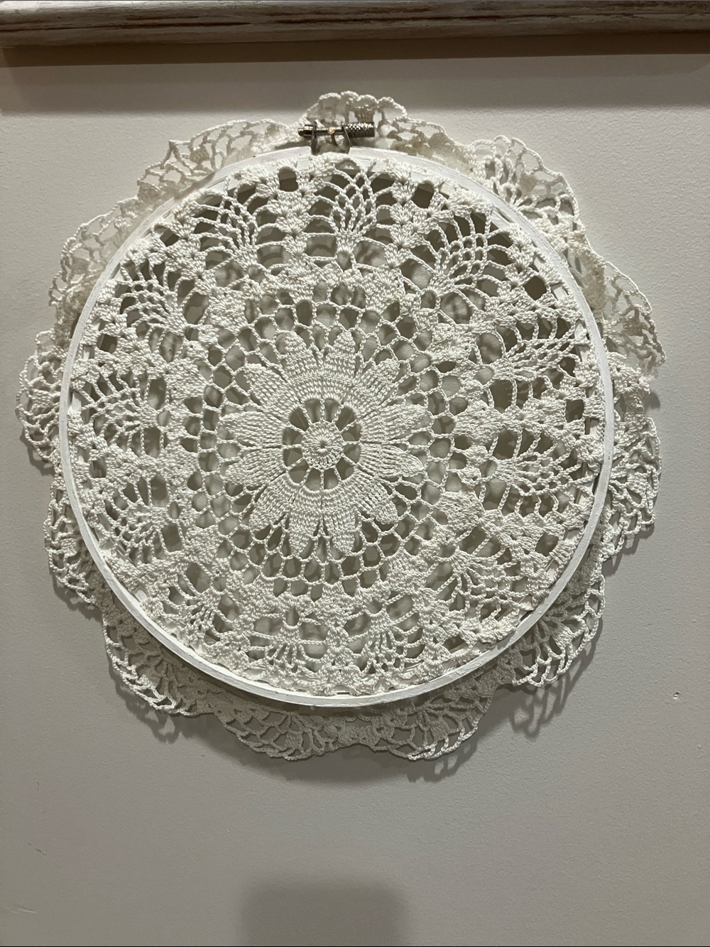 Hand crocheted doily in a decorative wall hoop. 11-1/2” across.